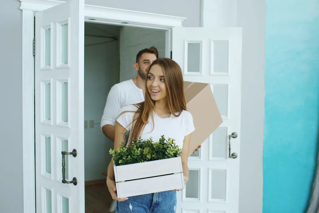 Paar trägt nach Feierabend die ersten Kartons in die neue Wohnung