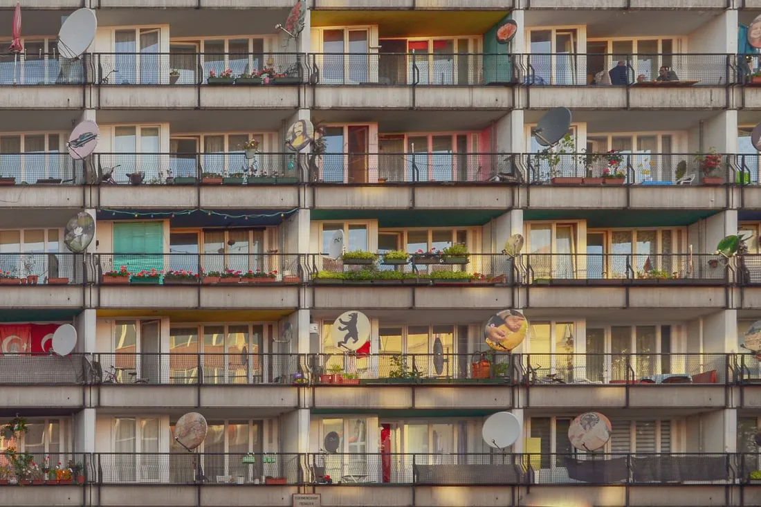 Balkonfassade eines Berliner Wohnhochhauses mit Satellitenschüsseln