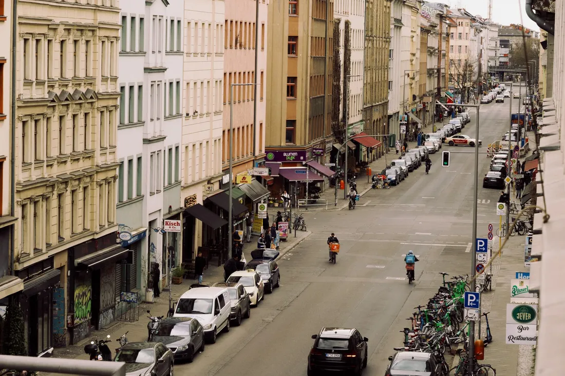 Berliner Wohnstraße mit beidseitig parkenden Autos und Ladengeschäften